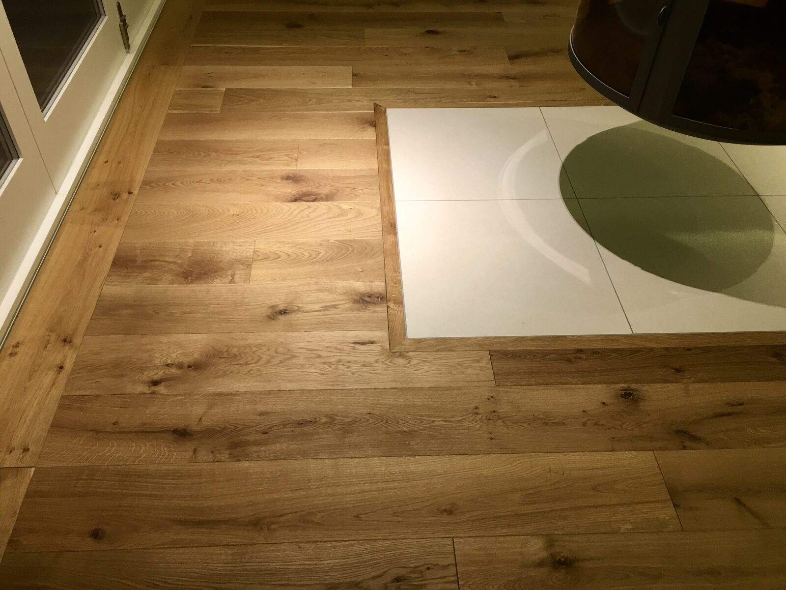 Finished wide-plank oak floor with rich grain laid through a kitchen