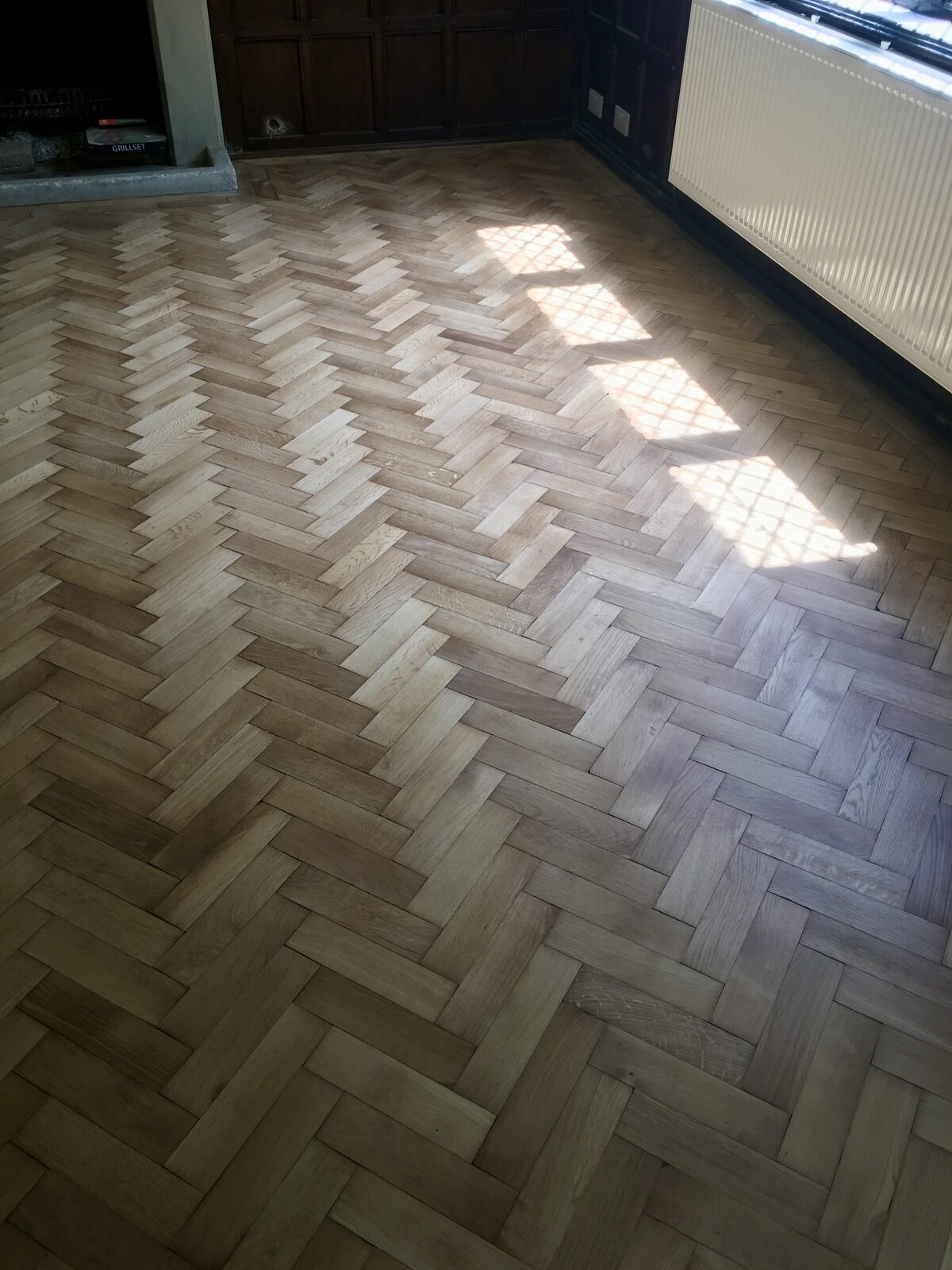 Restored oak herringbone parquet, of the kind we lay in Haslemere homes