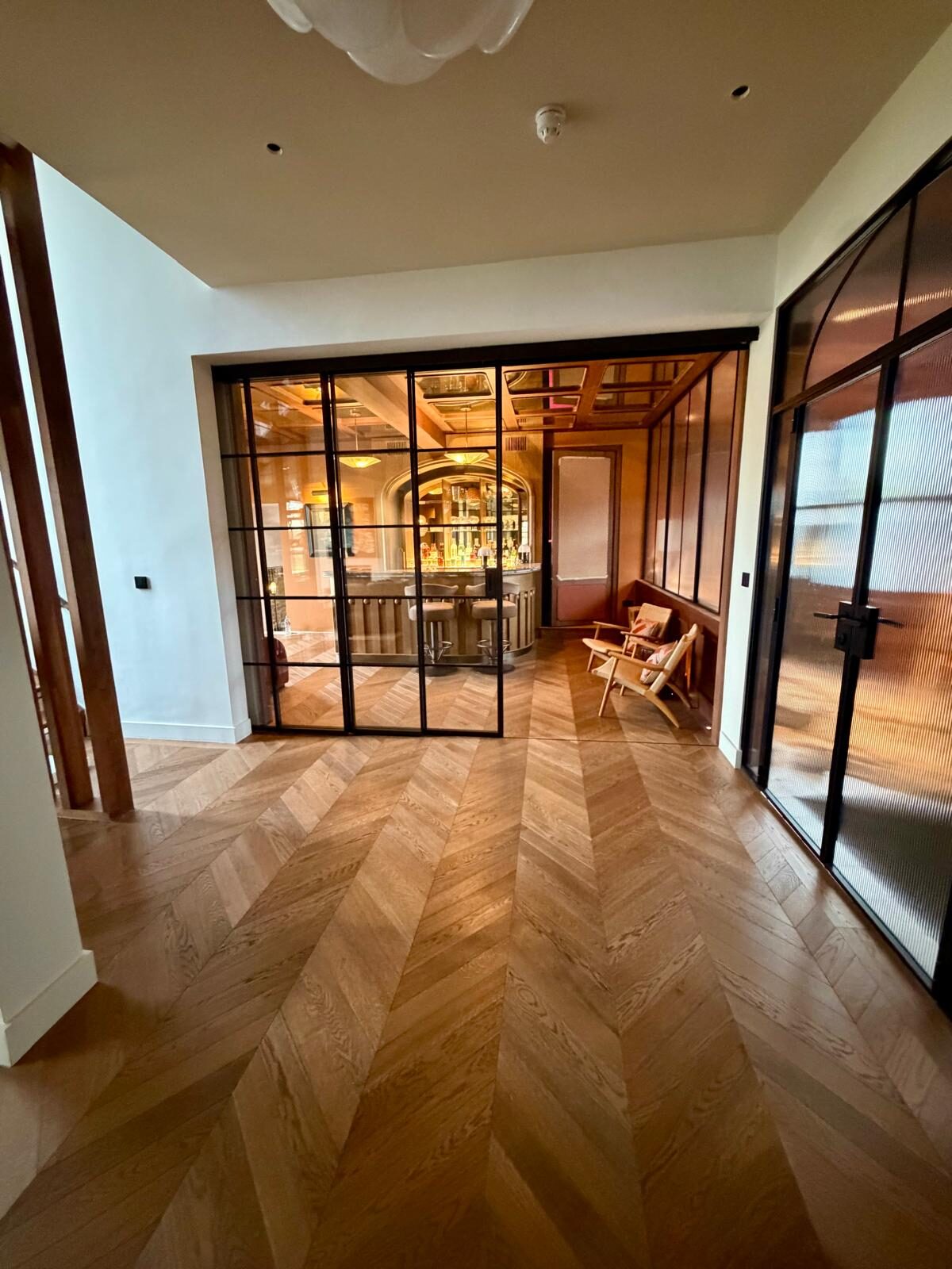 Oak chevron parquet flooring in a Crittall-glazed room