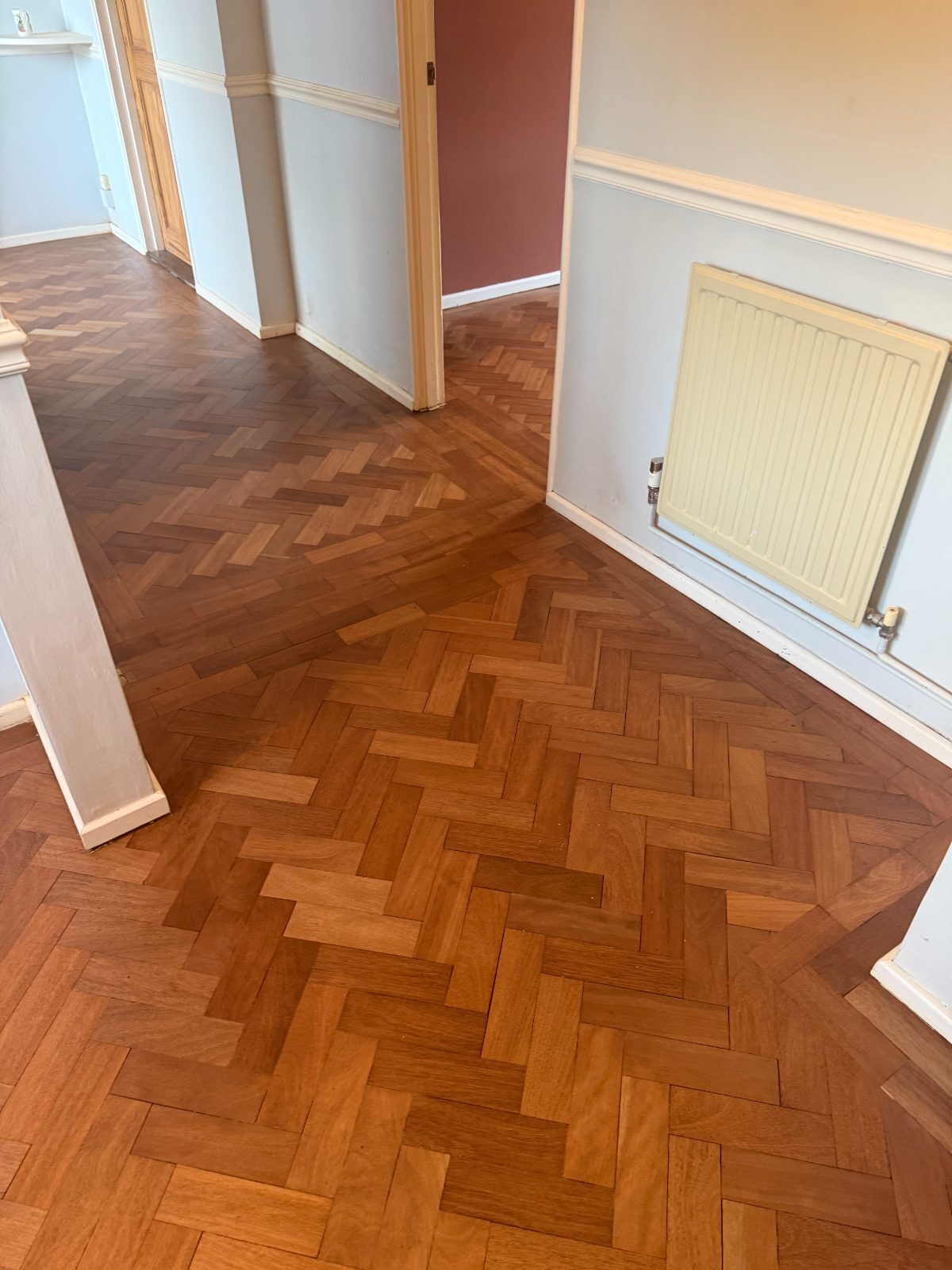 Restored reclaimed herringbone parquet floor in a West Wittering home, sanded and sealed to a warm honey tone