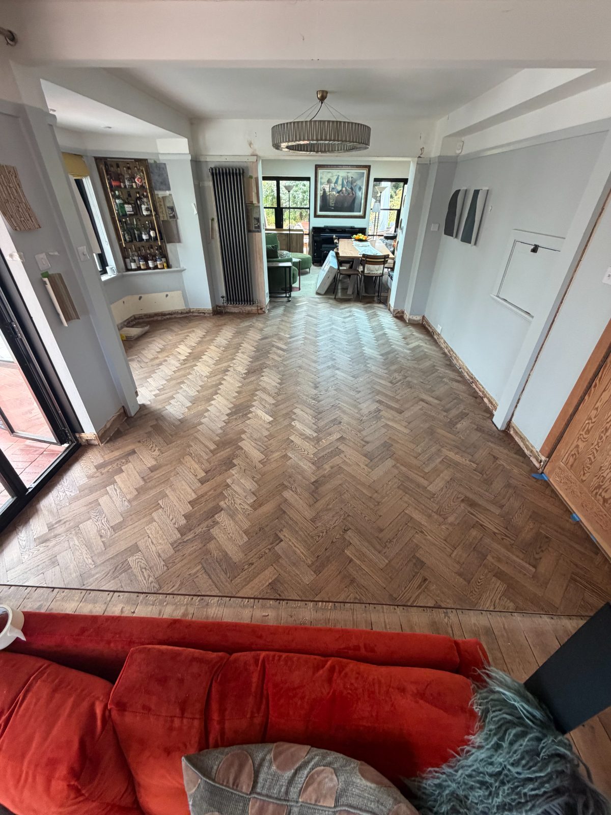 Finished oak herringbone parquet in a large open-plan Summerley Estate room, sanded to a warm natural tone