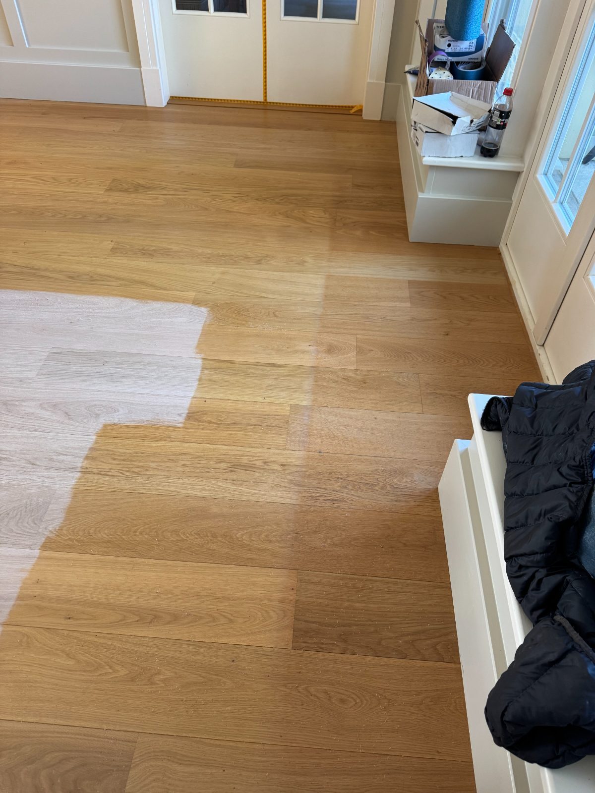Engineered oak plank floor mid-restoration, sanded back to bare wood on one side and re-oiled on the other, in a Bosham Hoe home